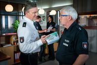Notruf Hafenkante – Haller (Hannes Hellmann, l.) will mit allen Kollegen ein Mitarbeitergespräch führen. Wolle (Harald Maack, r.) wird der Erste sein. Doch warum drückt ihm Haller im gleichen Atemzug eine Broschüre zur „Vorbereitung auf den Ruhestand“ in die Hand?