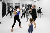 Puls – Hochschwangere Frau im Boxtraining mit anderen Frauen und Männern und einem Kind, das zuschaut