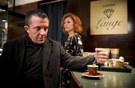 Tatort – Kaffee bei der Juwelierin: Jörn Weig (David Bennet, vorne) ist zu Besuch in Elisabeth Langes (Heike Trinker, hinten) Geschäft,