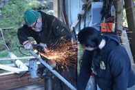 Fernab des Gesetzes – Sam Carlson und Breanna Miethe schneiden Materialien zu, um eine schwenkbare Zielscheibe und eine Gewehrbank für die Gemeinde zu bauen. (National Geographic für Disney/Wayne Moss)