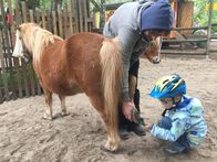 Ich bin Ich – Bevor Jakob reiten darf, muss er die Hufe auskratzen. Sein Trainer (li.) hilft ihm dabei.