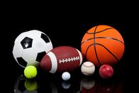 Sport – Verschiedene Sportbälle, darunter Basketball, American Football, Fußball, Tennisball, Baseball, Golfball und Cricketball auf schwarzem Hintergrund