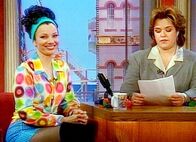 Die Nanny – Fran (Fran Drescher li.) beantwortet in der Rosie O'Donnell Show Zuschauerfragen zur Kindererziehung, die von der Gastgeberin Rosie (Rosie O'Donnell re.) vorgelesen werden.