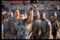 Gladiator – Obwohl jeder Kampf ihr letzter sein könnte, grüßen die Gladiatoren in der Arena Publikum und Kaiser. Maximus (Russell Crowe, M.) mit zwei seiner treuen Gefährten, Juba (Djimon Hounsou, r.) und Hagen (Ralf Moeller, l.).