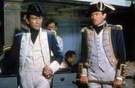 Des Königs Admiral – Kapitän Hornblower (Gregory Peck, re.) und Leutnant Bush (Robert Beatty, li.) warten gespannt, ob sie die Franzosen mit ihrer Idee, eine französische Flagge zu hissen, überlistet haben und unerkannt in deren Hafen einfahren können.