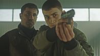 Hidden Agenda – Der kriminelle Pate Isak (Mahmut Suvakci, l.) bildet Teddys Neffen Nikola (Gustav Lindh) an der Waffe aus, um ihn als neuen Bodyguard aufzunehmen.