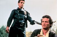 Mad Max – Auf seinem Rachefeldzug trifft Max (Mel Gibson, li.) auf Johnny the Boy (Tim Burns, re.), der seinen Partner Goose in Brand gesetzt hat.