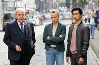 Rentnercops – Polizeipräsident Plocher (Michael Prelle, l.), Vicky Adam (Katja Danowski, M.) und Hui Ko (Aaron Le, r.) belügen die Rentnercops, um sie aus dem Fall der ermordeten Feministin Lisa rauszuhalten.