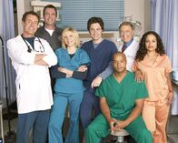 Scrubs - Die Anfänger – Von links nach rechts: Dr.Perry Cox (John C. McGinley), Der Hausmeister (Neil Flynn), Elliot Reid (Sarah Chalke), John "J.D". Dorian (Zach Braff), Chris Turk (Donald Faison), Dr. Bob Kelso (Ken Jenkins) und Judy Reyes (Carla Espinosa).
