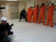 Lockdown – San Antonio, Texas: Der Produzent David Ross Smith filmt, wie ein Beamter Häftlinge abtastet.