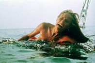 Der weiße Hai – Eine Frau (unbekannt) wird beim Schwimmen im Meer vor Amity von einem Hai angegriffen und tödlich verletzt.
