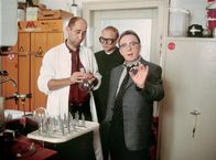 Tatort – Ihre Ermittlungen führen die Kommissare Ehrlicher (Peter Sodann, rechts) und Kain (Bernd Michael Lade, Mitte) auch ins Labor von Christine Werrling, wo sie sich von ihrem Assistenten Paulus (Manfred Möck) die Arbeit der Frau Professor erklären lassen.