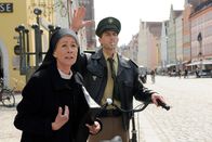 Um Himmels Willen – Schwester Felicitas (Karin Gregorek, l.) will mit dem Bus nach München fahren. Polizist Meier (Lars Weström, r.) soll auf ihr Fahrrad aufpassen.