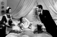 Verdacht – Zunächst ist Lina (Joan Fontaine, Mi.) vom Luxus, den ihr Ehegatte (Cary Grant, re.) ihr bietet, begeistert: ein luxuriöses Haus, teure Geschenke und sogar ein eigenes Hausmädchen (Heather Angel, li.). Doch bald zweifelt Lina: Woher kommt das ganze Geld?