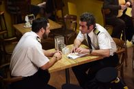 Mayday - Alarm im Cockpit – Kapitän Garanito Gomez (gespielt von Alex Karzis) und der Erste Offizier Ferreira Quintal (gespielt von Rodrigo Fernandez-Stoll) entspannen sich in einem Flughafenrestaurant, kurz bevor sie den Santa Barbara Airlines Flug 518 besteigen. Die Ermittler fragen sich später, ob die Kaffeepause der Piloten eine entscheidende Verzögerung bei den Flugvorbereitungen verursacht haben könnte. photo credit: Cineflix/Ian Watson