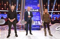 Quizduell - Olymp – Moderator Jörg Pilawa (M.) mit den Kandidat:innen des Teams "Kamera": Dem Schauspieler Stefan Jürgens (l.) und der Schauspielerin Esther Schweins (r.).