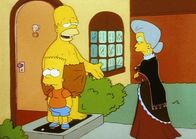 Die Simpsons – Belle (re.) beschwert sich bei Homer über seinen ungezogenen Sohn Bart.