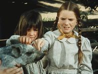 Unsere kleine Farm – Carrie Ingalls (Lindsay Sidney Greenbush, l.) und ihre Schwester Laura (Melissa Gilbert, r.) bestaunen auf ihrem Ausflug ein Schwein.
