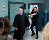 The Rookie – Der Richter Stevens (Jim Ortlieb, l.) wollte John Nolan (Nathan Fillion, r.) und weitere Besucher des Gerichts aus Platzgr¸nden nicht in den Bunker lassen und hatte sie sogar mit einer Waffe bedroht, die ihm John abgenommen hat.