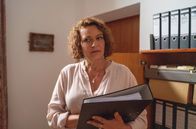 Watzmann ermittelt – Frau Maierhofer (Lilly Forgách) schleicht sich in das Büro ihres Kollegen und Vorgesetzten Roman Grosser. Ihr Blick verrät, der Inhalt des Ordners wirft Fragen auf.