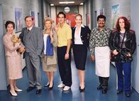 Bürgerbüro – V.l.: Trudi Roth als Adele Wehrli mit Fleurettli, Christoph Sommer als Dr. Wilhelm Wehrli, Sibylle Courvoisier als Theres Bütikofer, Beat Marti als Adrian Furrer, Stephanie Japp als Verena Probst, Anton Ponrajah als Tami und Gina Durler als Chick.