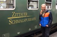 Mit Volldampf und Musik – Olaf Berger vor einem Waggon der Zittauer Schmalspurbahn