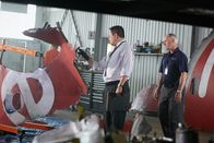 Mayday - Alarm im Cockpit – ONTARIO - RE-ENACTMENT - NTSC Investigator (played by Redd Ochao) looks over parts of the plane crash in the hanger while a BEA agent (played by a background performer) stands by.