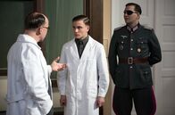 Charité – Otto (Jannik Schümann, M.) besteht sein Chirurgie-Examen bei Prof. Sauerbruch (Ulrich Noethen, l.). Sein Prüfungspatient ist kein Geringerer als Claus Schenk Graf von Stauffenberg (Pierre Kiwitt, r.).