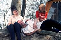 Camping, Camping – Familie sitzt erschöpft an einem Baum.