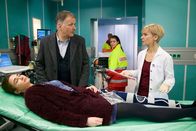 In aller Freundschaft – ARD/MDR IN ALLER FREUNDSCHAFT FOLGE 688, "Zu einem hohen Preis" Uhr im ERSTEN. Das Notarztteam (Komparsen) liefern Tatjana Geiger (Natalia Witmer, liegend) ein. Dr. Roland Heilmann (Thomas Rühmann, li.) hat die junge Frau am Vortag vorzeitig entlassen. Nun hat sie durch eine Wundheilungsstörung sowie eine Beinvenenthrombose eine Lungenembolie erlitten. Ihr Zustand ist kritisch und Dr. Kathrin Globisch (Andrea Kathrin Loewig, re.) muss Tatjana in ein künstliches Koma versetzen. Roland macht sich große Vorwürfe, unter dem Druck von Abaris, gegen seine Prinzipien gehandelt und Tatjana vorzeitig entlassen zu haben.