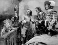 Die drei Musketiere – DArtagnan (Gene Kelly, 2.v.l.) wird von seinen Freunden, den drei Musketieren Pathos (Gig Young, li.), Athos (Van Heflin, 2.v.r.) und Aramis (Robert Coote, re.) überrascht.