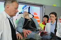 In aller Freundschaft – Nachdem nach einem Banküberfall eine angeschossene Polizistin eingeliefert wurde, hat die Polizei nun den Täter (Jorres Risse, liegend) gefasst. Auch er ist verletzt. Dr. Roland Heilmann (Thomas Rühmann, li.) und Dr. Maria Weber (Annett Renneberg, re.) vermuten, dass der Schuss die Arterie verletzt hat. Durch die genaue Projektilbeschreibung der Notärztin (Sarah Arntz, 2.v.re.) können die beiden Ärzte das Ausmaß halbwegs einschätzen.