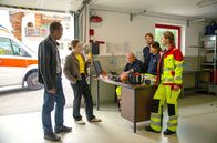 Watzmann ermittelt – Vor Hauptkommissar Jerry Paulsen (Peter Marton, l.) und Kommissarin Sophia Strasser (Katharina Leonore Goebel, r.) halten die Sanitäter Ritschi (Peter Finsterwalder, M.), Bruno (Timo Gasteger, 3.v.r.), Bertha (Vanessa Jung, 2.v.r.) und Luise (Sophie Röhrmoser, r.) zusammen. Doch die Kommissare haben haben einen Zettel mit einer Drohung bei einem der Sanitäter gefunden.