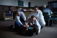 The Lazarus Project – Schon bald muss Ben (Paul Walker, liegend) erkennen, dass Father Ezra (Bob Gunton, l.) und "Berater" Avery (Lambert Wilson, r.) dem Patienten Reeds (Tony Curran, M.) nichts entgegenzusetzen haben ...