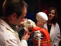 Hunter Hunted – Dr. Greg Erickson and Dr. Luanne Freer compare cougar skull to puncture holes in life vest.