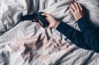 Unfall, Selbstmord oder Mord – Cropped shot of woman lying on bed with gun in her hand
