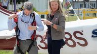 Airplane Repo - Die Inkasso-Piloten – Valerie Kennedy helps the debtor into his parachute.