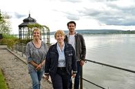 WaPo Bodensee – Immer für eine Überraschung gut: Mechthild Fehrenbach (Diana Körner, li.) wollte die Familienkasse aufbessern und hat ahnungslos Jakob Frings (Max König, re.), den neuen Kollegen von Nele (Floriane Daniel, mi.) als Untermieter auserkoren.